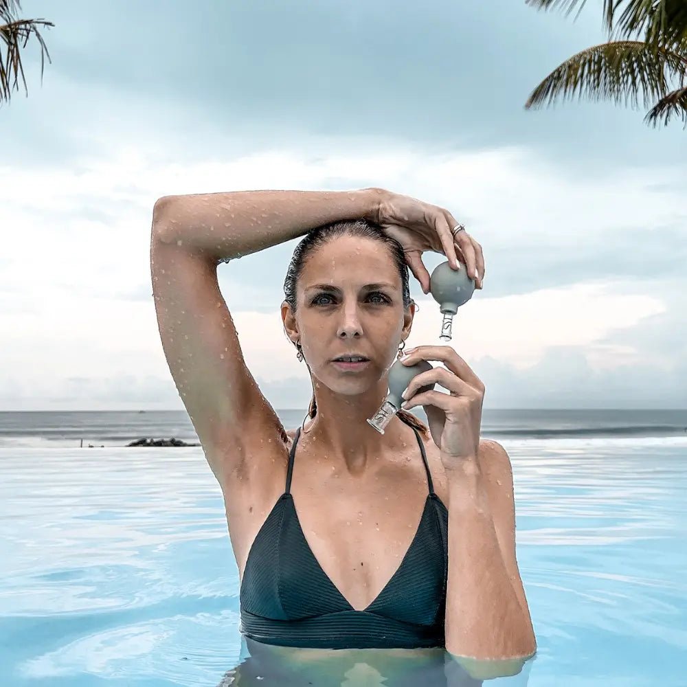 Schröpfgläser Anwendung im Pool mit Palmen im Hintergrund