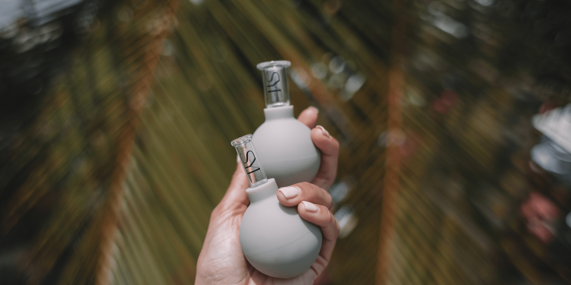 Zwei beige Facial Cups in der Hand einer Frau 