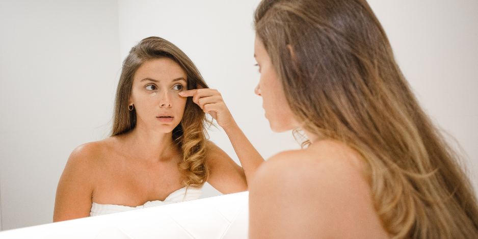 Ursache für Tränensäcke - Frau vor dem Spiegel 